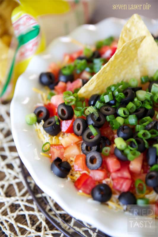Seven Layer Dip // Perfect for parties, tail-gaiting, football season, or other various get togethers. Seven Layer Dip is an all-around tasty dip everyone loves! | Tried and Tasty