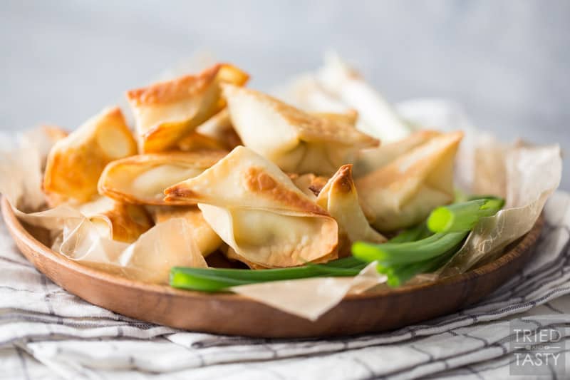 Plate of wontons with green onion garnish on a linen napkin