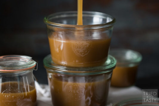 Glass jar being filled with homemade caramel