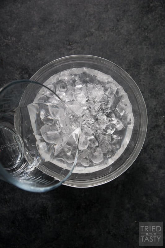 Water being poured into a glass bowl of ice