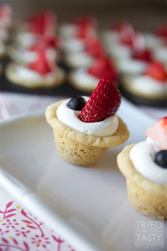 Red White & Blue Strawberry Blueberry Sugar Cookie Cups with Coconut Cream Cheese Filling // These scrumptious little treats are perfect party poppers! They are mini, fit right in the palm of your hand, and will be gobbled up in no time. With the tiniest hint of coconut, you'll be left wanting more! | Tried and Tasty