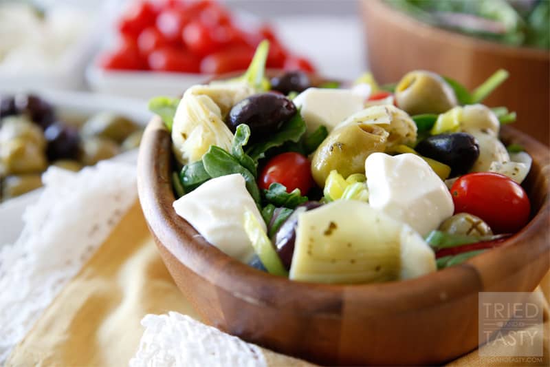 Mediterranean Salad With A Creamy Feta Dressing // The most wonderful Mediterranean Salad featuring the delicious flavors of marinated artichokes, fresh mozzarella, savory olives, and red onion. Finish it off with the most delectable creamy feta dressing for a knockout pairing! | Tried and Tasty