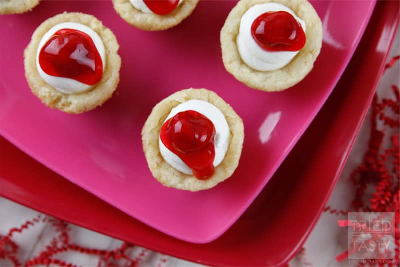Mini Cherry Cheesecake Sugar Cookie Cups // These delicious little bite-sized bits of heaven are perfect for Valentine's Day! They are mini, fit right in the palm of your hand, and will be gobbled up in no time. With the tiniest hint of coconut, you'll be left wanting more! | Tried and Tasty