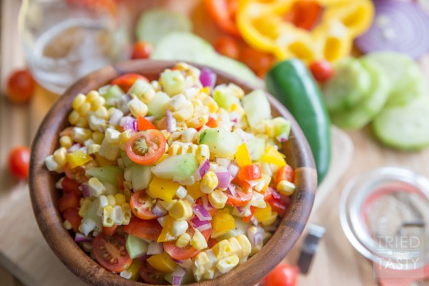 Fresh Sweet Corn Salad // Nothing screams summer like fresh corn! Am I right? I love fresh sweet corn all kinds of different ways, but I especially love it in this yummy salad. Jam packed with all kinds of bright fun veggies, coated in a tangy refined sugar-free dressing! Pefect for any potluck, BBQ, or picnic. | Tried and Tasty