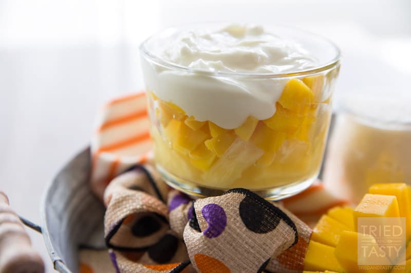Tropical Candy Corn Parfait // Halloween doesn't have to be ALL about sugar comas. There's healthy ways to celebrate as well! Bring a piece of the tropics close to you with this tropical fruit & yogurt parfait. Layered with pineapple, mango, & coconut yogurt. A delicious & healthy treat! | Tried and Tasty