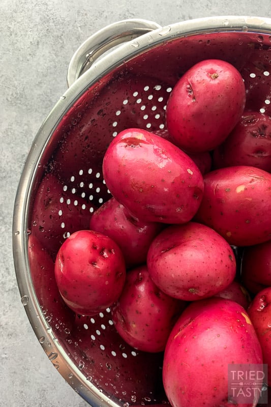 10 lbs of red potatoes in a silver colander