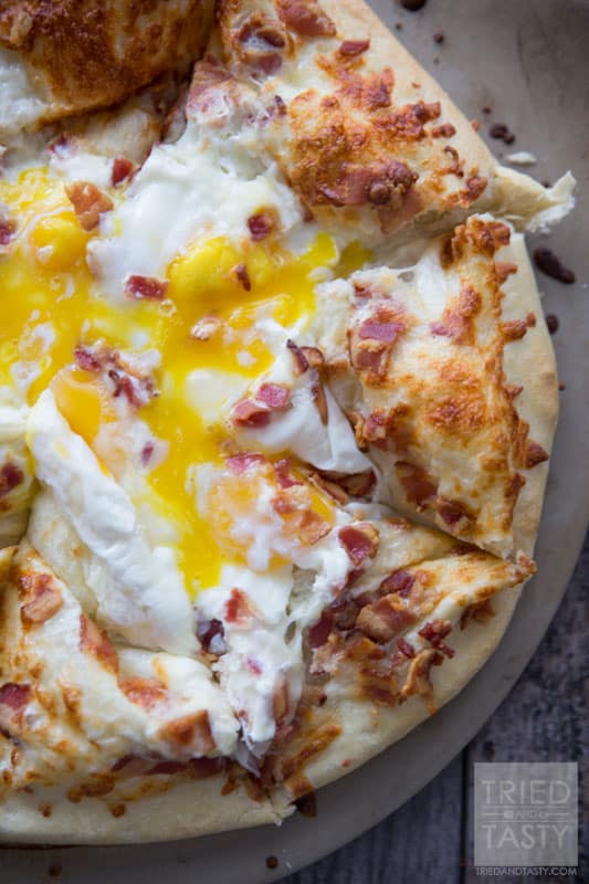 Breakfast Pizza // Make breakfast fun with this delicious pizza! Eggs, bacon and cheese + a crust is all you need. Great the morning of and also still tasty as leftovers! | Tried and Tasty