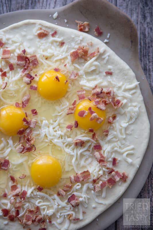 Breakfast Pizza // Make breakfast fun with this delicious pizza! Eggs, bacon and cheese + a crust is all you need. Great the morning of and also still tasty as leftovers! | Tried and Tasty