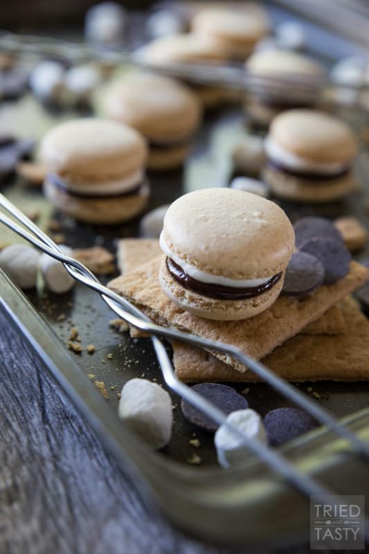 S'mores French Macarons // Whether it's National S'mores Day or not, these french macarons are the PERFECT way to celebrate anytime! With a tasty graham macaron, marshmallow buttercream, and chocolate ganache - these little babies will be devoured by everyone! | Tried and Tasty