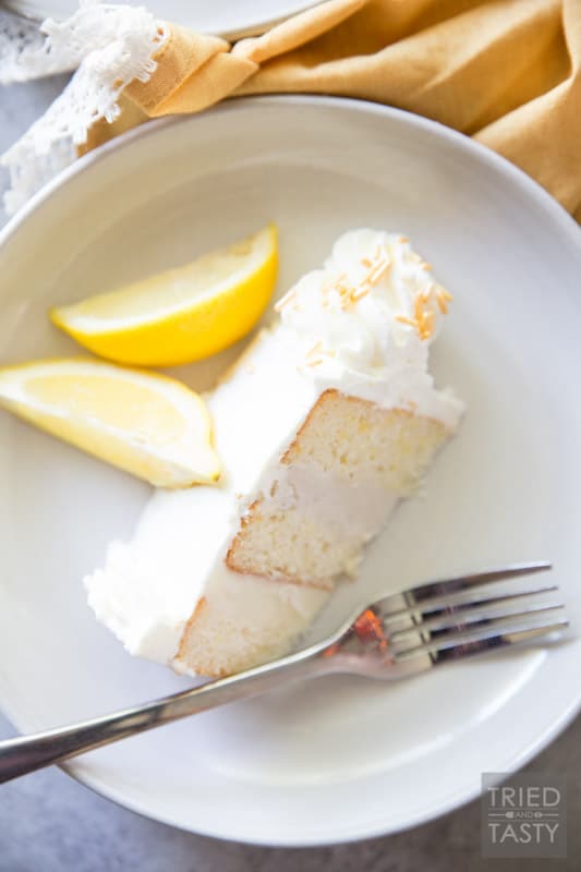Lemon Lovers Ice Cream Cake // Calling all lemon lovers, this ice cream cake screams summer with the most delicious lemon cake sandwiched between a layer of lemon ice cream and a layer of vanilla bean ice cream covered in light and fluffy lemon whipped cream frosting! | Tried and Tasty