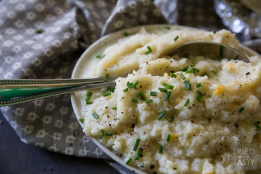 Cheesy Roasted Garlic Mashed Cauliflower // Move over mashed potatoes, there's a new side dish in town. This mashed cauliflower recipe would fit in perfectly on your holiday dinner table! Give 'em a try - you won't be disappointed! | Tried and Tasty