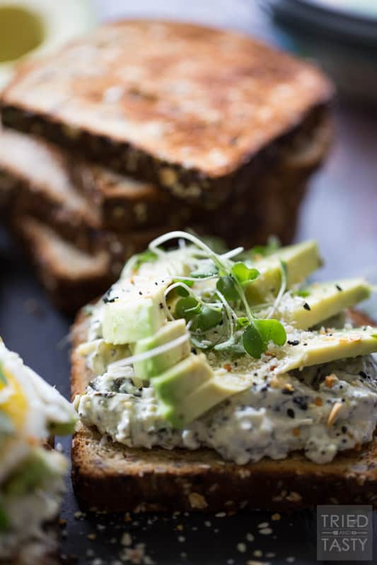 Savory Avocado Toast // This quick and easy snack that could double as breakfast or triple as lunch is simple to make & packed with nutrients! The twist? A smattering of spinach & artichoke dip underneath! | Tried and Tasty