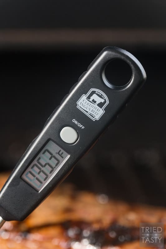 A digital meat thermometer showing the temperature of the steak on the grill. In this case, 135.3 degrees F.