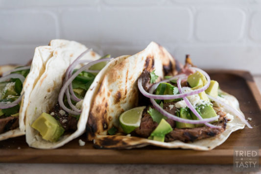 A side angle showing steak tacos on a cutting board.